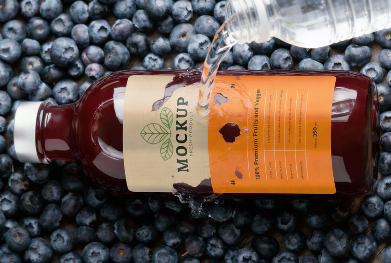 Bottle of juice being poured on water with label disappearing
